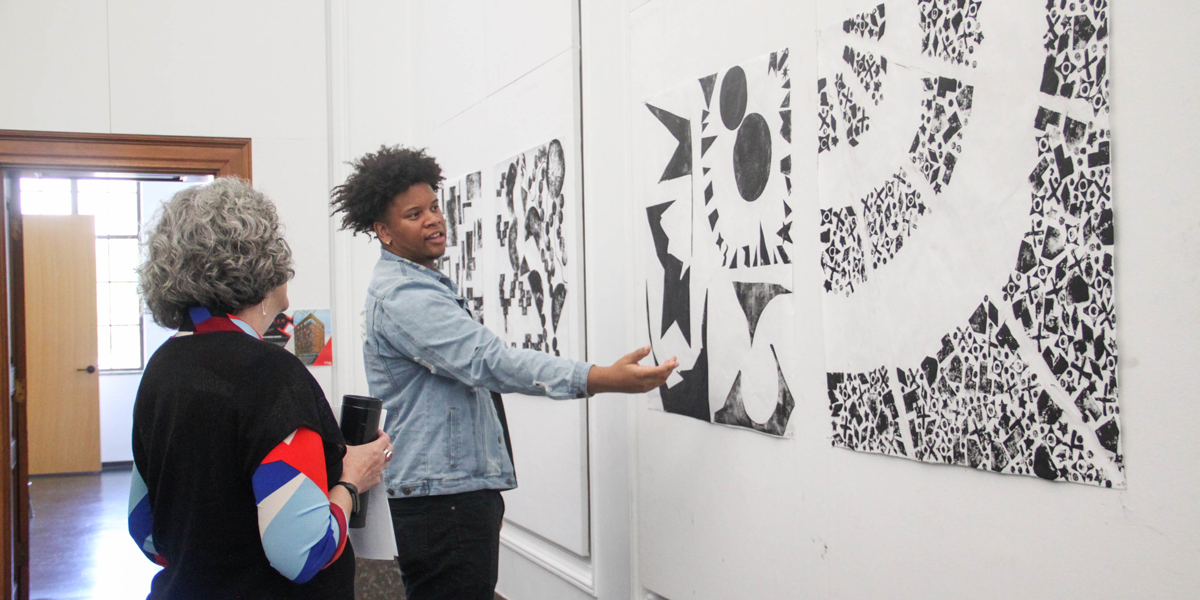 Student and teacher looking at wall art.